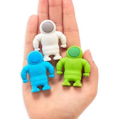 Three OOLY Astronaut erasers in palm of hand