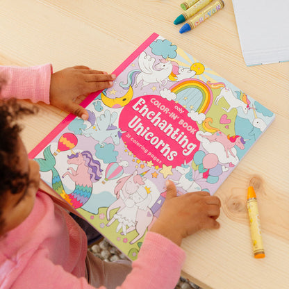 Kid hands holding Enchanting Unicorns Coloring Book