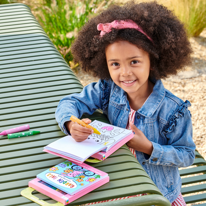 Girl on park bench coloring a page from a set of Carry Along! Coloring Book and Crayon Set - Garden Pals