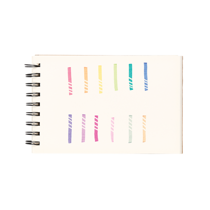 White sketchbook with 12 color swatches and eraser lines from the OOLY Make No Mistake Erasable Markers