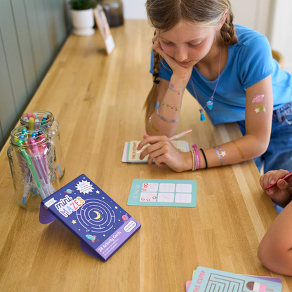 Kids playing card game from OOLY Mini Mazes Activity Cards set