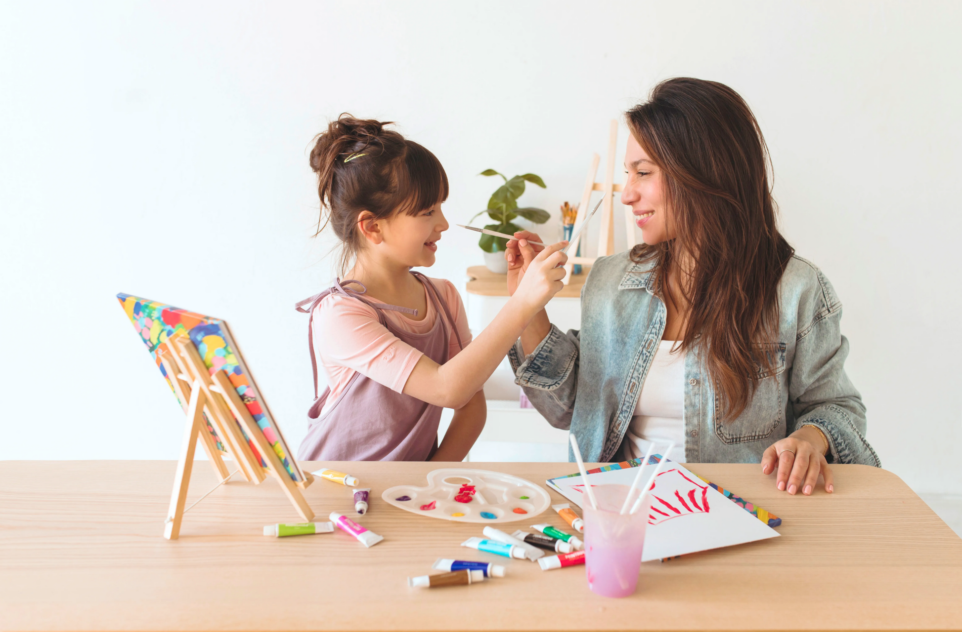 Girl and woman playing with paintbrushes in painting setting with OOLY Paintology Acrylic Paint Set - Classic Colors