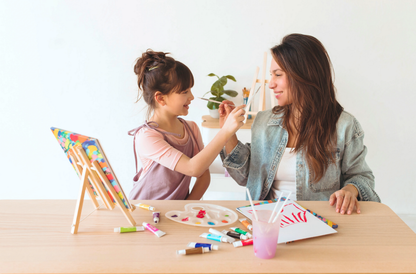 Girl and woman playing with paintbrushes in painting setting with OOLY Paintology Acrylic Paint Set - Classic Colors
