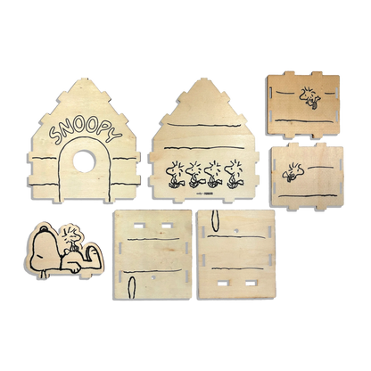 Flat lay of pieces of birdhouse from the OOLY x Peanuts Color-in Wooden Birdhouse Kit