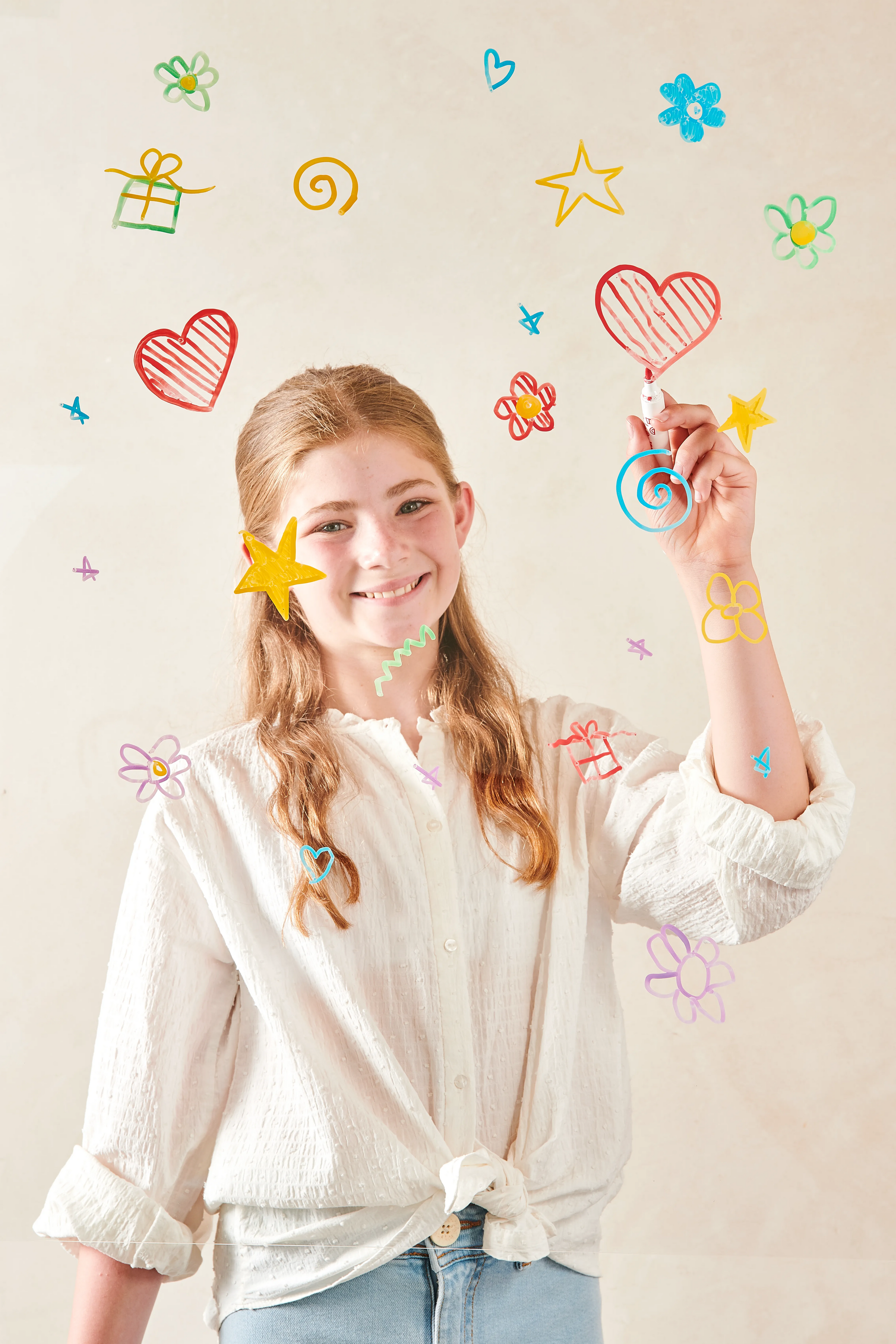 Girl coloring hearts, stars and flowers with OOLY Vivid Pop! Water Based Paint Markers
