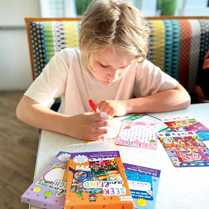 Kid in restaurant writing in OOLY Word Search Activity Card set